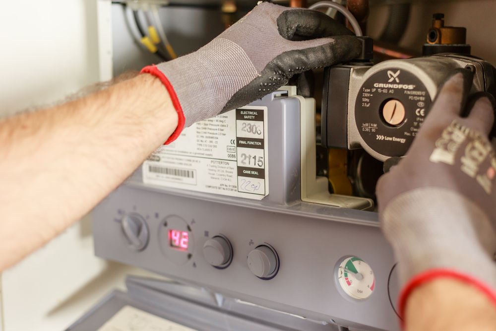 Technicien en gants de travail intervenant sur une chaudière